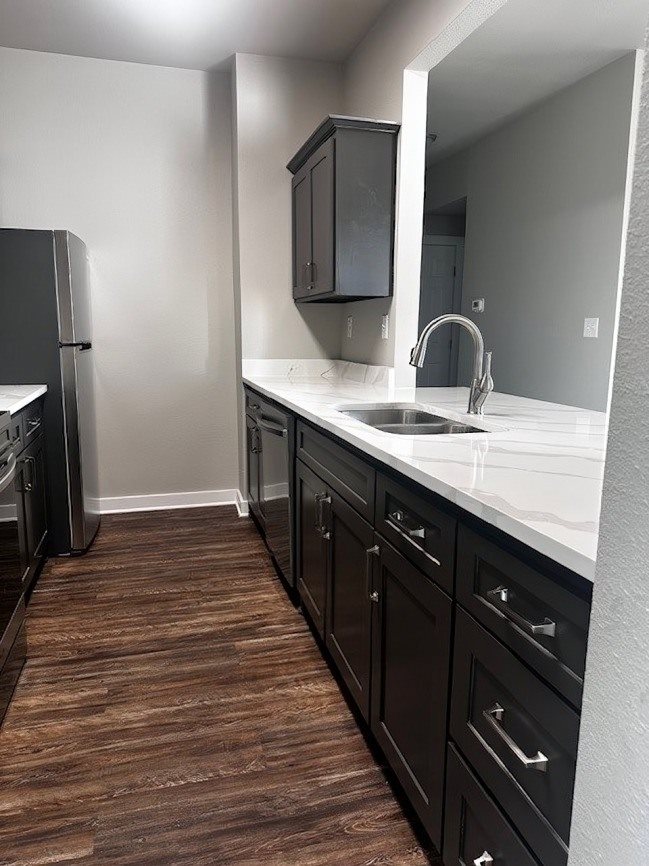 A kitchen with dark wood floors and white countertops.